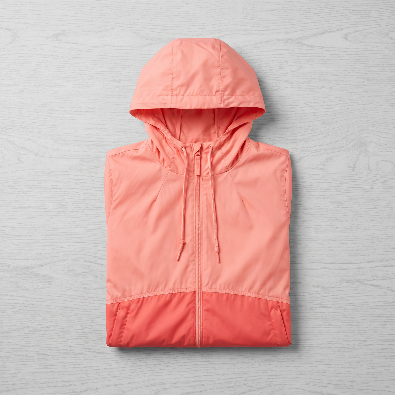 Kids waterproof windbreaker jacket by Columbia folded on light wood background